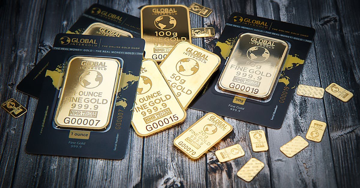 A collection of fine gold bars displayed on a textured wooden surface.